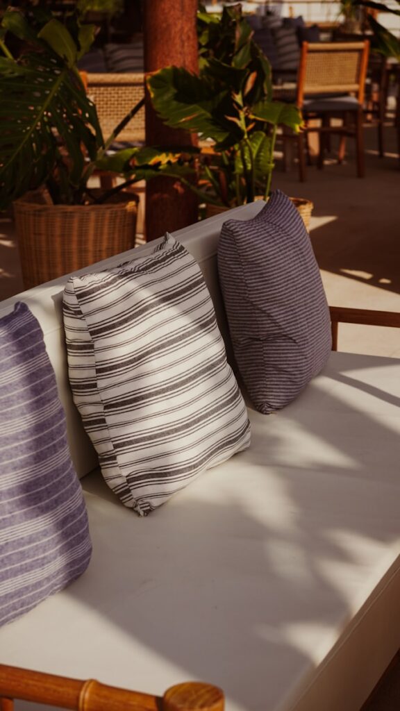 Outdoor lounge seating with striped pillows and plants.
